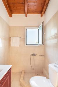 a bathroom with a toilet and a window at Maisonnette D'Amira in Eretria