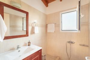 a bathroom with a sink and a mirror and a shower at Maisonnette D'Amira in Eretria +23 photos