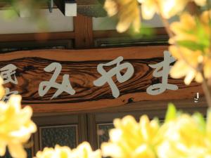 un cartel de madera con escritura japonesa. en Minshuku Miyama, en Yamanouchi