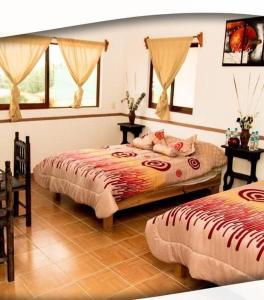 1 dormitorio con 2 camas y 2 ventanas en Posada Acaxiloco, en Cuetzalán del Progreso