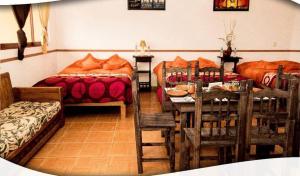 una camera con tavolo e letto e una camera da letto di Posada Acaxiloco a Cuetzalan del Progreso