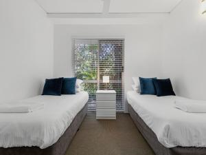 Dos camas en una habitación con ventana. en Picture Point 4 - 500m to Hastings St & Noosa Beach, en Noosa Heads