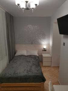 1 dormitorio con 1 cama con un árbol en la pared en Gościnny Dom Kaola, en Rewal