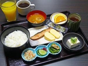 京都市にあるホテル法華クラブ京都の米、野菜、果物が載った食事のトレイ