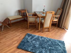 jadalnia ze stołem, krzesłami i dywanem w obiekcie Hajdúszoboszló Toscana Panoráma w Hajduszoboszlo