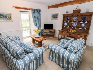 a living room with two couches and a television at Garden Cottage in Haverfordwest