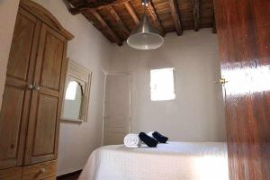 una camera da letto con un letto e un asciugamano sopra di Agroturismo Casa Morna Ibiza a Sant Carles de Peralta