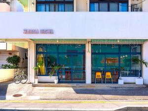 a restaurant with two orange chairs in front of a building at Seawall Hostel in Chatan