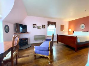 a bedroom with a bed and a desk and a television at Excelsior Inn in Eugene