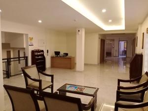 a lobby with chairs and a table and a desk at HOTEL GEO in Cochin