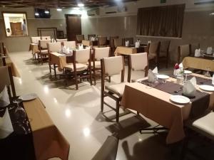 a dining room with tables and chairs in a room at HOTEL GEO in Cochin +13 photos