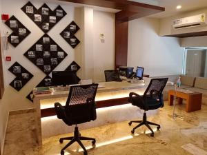 un bureau avec deux chaises et un bureau avec deux ordinateurs dans l'établissement HOTEL GEO, à Cochin