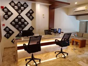an office with two chairs and a desk with two computers at HOTEL GEO in Cochin