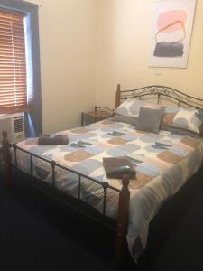um quarto com uma cama com uma colcha em Cornucopia hotel em Wallaroo