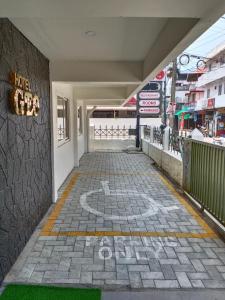 an empty walkway with a sign on the side of a building at HOTEL GEO in Cochin