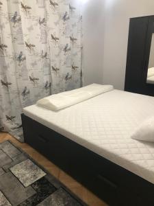 a bed in a bedroom with a white mattress at Apartament Colina in Cluj-Napoca
