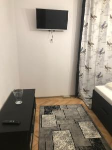 ein Wohnzimmer mit einem TV an der Wand in der Unterkunft Apartament Colina in Cluj-Napoca