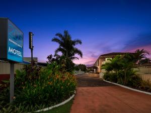 una señal de motel frente a un edificio con una palmera en Kennedy Drive Airport Motel en Tweed Heads