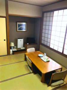 a room with a wooden table and chairs and windows at The Celecton Fukushima in Fukushima