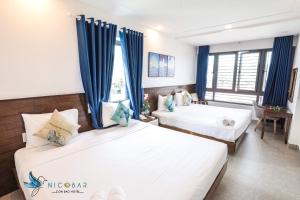 Giường trong phòng chung tại Nicobar Con Dao Hotel