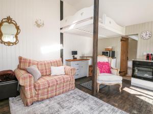 un soggiorno con divano e sedia di Woodmancote Lodge a Linchmere