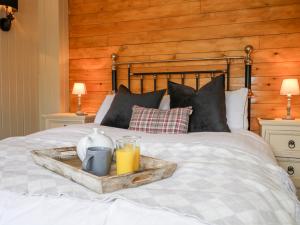 a tray with a tray of orange juice on a bed at Woodmancote Lodge in Linchmere