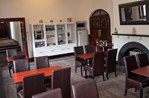 a dining room with tables and chairs and a fireplace at Hydro Hotel in Leeton