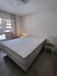 Un dormitorio con una cama grande y una silla. en Tähtisara, en Syöte 9 fotos más
