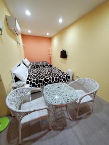 Habitación con 1 cama, 2 mesas y sillas en 芽哦小窩Ya OH Rooms en Nangan