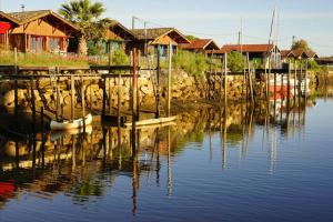 ein Spiegelbild einer Anlegestelle im Wasser mit Häusern in der Unterkunft Les pignots Logement T2 Bassin Arcachon in Gujan-Mestras