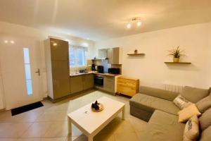un salon avec un canapé et une table dans l'établissement Les pignots Logement T2 Bassin Arcachon, à Gujan-Mestras