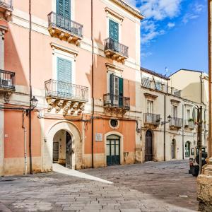 シラクーサにあるCasa sul Cortile in Ortigiaの通りに面したピンク色の大きな建物