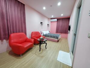 sala de estar con sillas rojas y sofá en 芽哦小窩Ya OH Rooms en Nangan