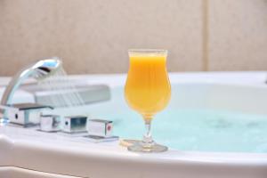 a glass of orange juice sitting on top of a bath tub at Platinum Park in Taif