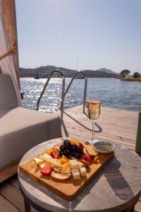 einen Teller mit Essen auf einem Tisch mit einem Glas Wein in der Unterkunft D PLAJ REZİDANS in Yalıkavak