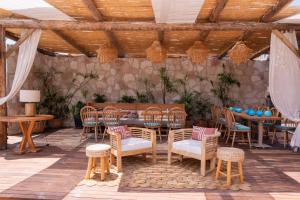een patio met een tafel en stoelen in een kamer bij D PLAJ REZİDANS in Yalıkavak