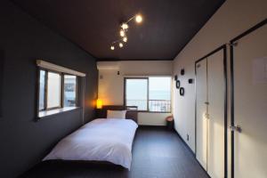 Un dormitorio con una cama blanca y una ventana. en Awaji Aquamarine Resort #1 BBQ OK! - Self Check-In Only, en Akashi