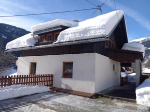 a house covered in snow on a mountain at Appartement Jana in Flattach