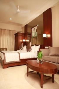 a bedroom with a bed and a couch and a table at Hotel Golden Tower Near Heritage Street in Amritsar +30 photos