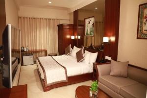 a hotel room with a bed and a couch at Hotel Golden Tower Near Heritage Street in Amritsar