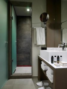 a bathroom with a shower with a sink and a shower at Kakkos Beach Hotel - Adults Only in Ierápetra