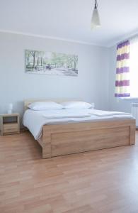 ein Schlafzimmer mit einem Bett mit einem Bettrahmen aus Holz in der Unterkunft Apartament Rodzinny w Zatorze in Zator