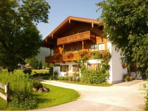 ein großes Holzhaus mit Balkon in der Unterkunft Ferienwohnung Rennerlehen in Schönau am Königssee