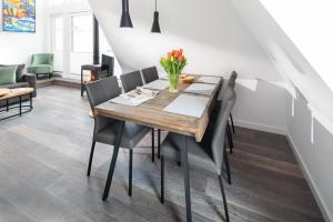 Un comedor con mesa y sillas de madera. en Haus Insulaner Tolle 8, en Norderney