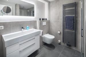 Un baño con un lavabo blanco y un inodoro. en Haus Insulaner Tolle 8, en Norderney 26 fotos más