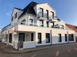 un gran edificio blanco con techo negro en Haus Insulaner Tolle 8, en Norderney