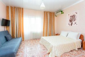 アナパにあるГостевой Дом Мароのベッドルーム(ベッド1台、青いソファ付)