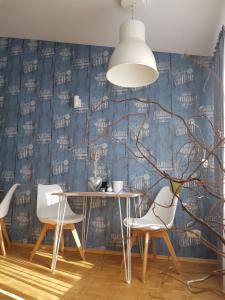 a dining room with a table and chairs and a blue wall at ARRIVEL Pension Pliening - bisher Novitel in Pliening