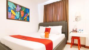 Schlafzimmer mit einem Bett mit Wandgemälde in der Unterkunft RedDoorz Plus @ Costa Roca Balamban in Cebu City