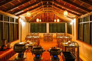 a room with tables and chairs with pots and pans at Agraharam Resorts in Thirunelli